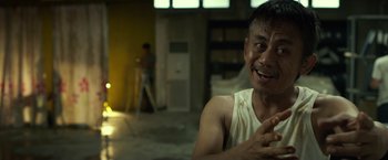 Movie still from “The Raid 2” (2014), directed by Gareth Evans – A man sitting in the middle of an empty room; Close Up shot, Over the shoulder angle