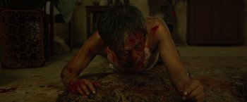 Movie still from “The Raid 2” (2014), directed by Gareth Evans – A man with blood all over his face and chest; Close Up shot, High angle