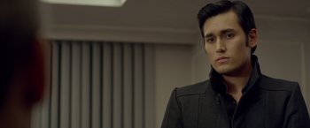Movie still from “The Raid 2” (2014), directed by Gareth Evans – A man in a black jacket standing in front of a wall; Close Up shot, Over the shoulder angle