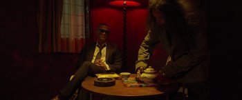 Movie still from “The Raid 2” (2014), directed by Gareth Evans – A man sitting at a wooden table with a woman; Medium shot, Low angle