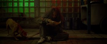 Movie still from “The Raid 2” (2014), directed by Gareth Evans – A person sitting on the ground holding a piece of paper; Medium shot, Overhead angle