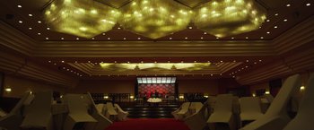 Movie still from “The Raid 2” (2014), directed by Gareth Evans – A stage in a large room with lights on the ceiling; Extreme Wide shot, Low angle