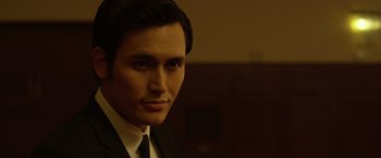 Movie still from “The Raid 2” (2014), directed by Gareth Evans – A person wearing a suit and tie; Close Up shot, Low angle