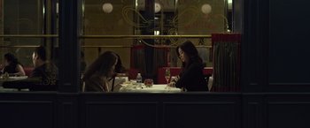 Movie still from “The Raid 2” (2014), directed by Gareth Evans – Two women sitting at a table in front of a glass of wine; Wide shot, High angle