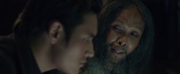 Movie still from “The Raid 2” (2014), directed by Gareth Evans – A man with a beard is looking at a man with long hair; Close Up shot, Over the shoulder angle