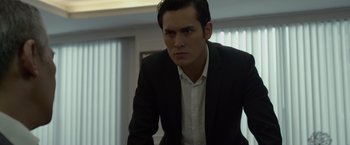 Movie still from “The Raid 2” (2014), directed by Gareth Evans – A man wearing a suit and tie standing in a room; Close Up shot, Low angle