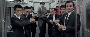 Movie still from “The Raid 2” (2014), directed by Gareth Evans – A group of men in suits and ties on top of a train; Medium shot, Low angle