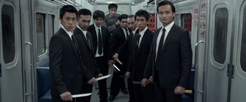 Movie still from “The Raid 2” (2014), directed by Gareth Evans – A group of men standing next to each other holding knifes in their hands; Medium shot, High angle