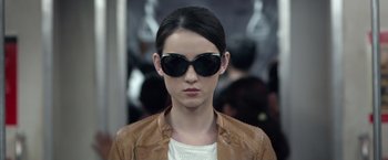 Movie still from “The Raid 2” (2014), directed by Gareth Evans – A woman wearing sunglasses and a leather jacket; Close Up shot, Over the shoulder angle