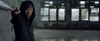 Movie still from “The Raid 2” (2014), directed by Gareth Evans – A man in a black hoodie is standing in a room; Close Up shot, Over the shoulder angle