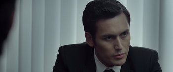 Movie still from “The Raid 2” (2014), directed by Gareth Evans – A person wearing a suit and tie; Close Up shot, Over the shoulder angle