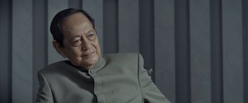 Movie still from “The Raid 2” (2014), directed by Gareth Evans – An older man wearing a gray jacket and a gray shirt; Close Up shot, Low angle