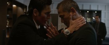 Movie still from “The Raid 2” (2014), directed by Gareth Evans – Two men in business suits touching each other's hands; Close Up shot, Low angle