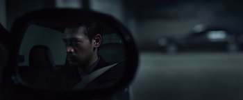 Movie still from “The Raid 2” (2014), directed by Gareth Evans – A man in a suit looking into a mirror; Close Up shot, Over the shoulder angle