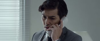 Movie still from “The Raid 2” (2014), directed by Gareth Evans – A person talking on a cell phone; Close Up shot, Low angle