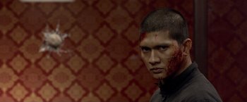 Movie still from “The Raid 2” (2014), directed by Gareth Evans – A man with blood all over his face and head; Close Up shot, Over the shoulder angle