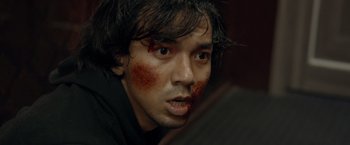 Movie still from “The Raid 2” (2014), directed by Gareth Evans – A man with blood all over his face; Close Up shot, High angle
