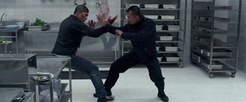Movie still from “The Raid 2” (2014), directed by Gareth Evans – Two men are fighting in a kitchen with blood on their hands; Medium shot, High angle