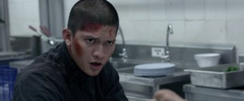 Movie still from “The Raid 2” (2014), directed by Gareth Evans – A young man with blood on his face in a kitchen; Close Up shot, Over the shoulder angle