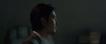 Movie still from “The Raid 2” (2014), directed by Gareth Evans – A person wearing a suit and tie; Close Up shot, Over the shoulder angle