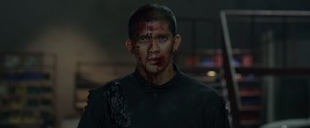 Movie still from “The Raid 2” (2014), directed by Gareth Evans – A person with blood on his face; Close Up shot, Over the shoulder angle