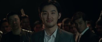 Movie still from “The Raid 2” (2014), directed by Gareth Evans – A man in a gray suit and a white shirt; Close Up shot, Over the shoulder angle