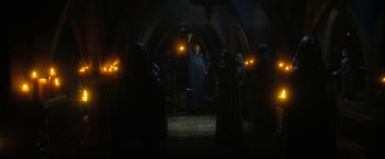 Movie still from “The Sandman” (2022), created by Neil Gaiman – A group of people standing in a dark room with lights; Wide shot, Low angle