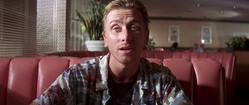 Movie still from “Pulp Fiction” (1994), directed by Quentin Tarantino – A person sitting in a room; Close Up shot, Over the shoulder angle