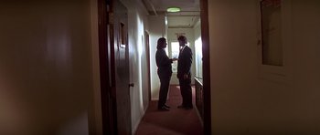 Movie still from “Pulp Fiction” (1994), directed by Quentin Tarantino – Two people standing in a hallway talking to each other; Wide shot, Low angle