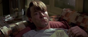 Movie still from “Pulp Fiction” (1994), directed by Quentin Tarantino – A person laying on a couch; Close Up shot, High angle