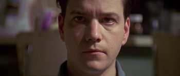 Movie still from “Pulp Fiction” (1994), directed by Quentin Tarantino – A man's face in a dark room; Close Up shot, Low angle