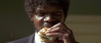 Movie still from “Pulp Fiction” (1994), directed by Quentin Tarantino – A person eating a hamburger; Extreme Close Up shot, Low angle