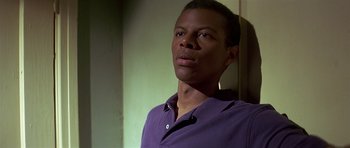 Movie still from “Pulp Fiction” (1994), directed by Quentin Tarantino – A man in a purple shirt is standing in a room; Close Up shot, Low angle