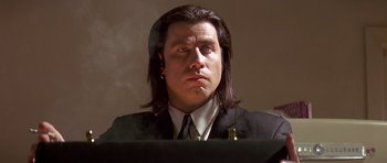 Movie still from “Pulp Fiction” (1994), directed by Quentin Tarantino – A man with long hair wearing a suit and tie; Close Up shot, Low angle