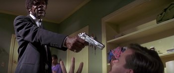 Movie still from “Pulp Fiction” (1994), directed by Quentin Tarantino – A man is holding a gun up to a woman's face; Close Up shot, Low angle