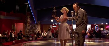Movie still from “Pulp Fiction” (1994), directed by Quentin Tarantino – A man and a woman are performing on a stage; Medium shot, Low angle