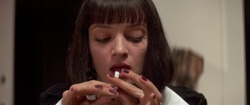 Movie still from “Pulp Fiction” (1994), directed by Quentin Tarantino – A woman is putting a pill in her mouth; Close Up shot, Overhead angle