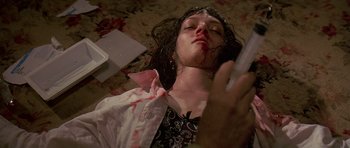 Movie still from “Pulp Fiction” (1994), directed by Quentin Tarantino – A woman laying on the ground with blood all over her face; Close Up shot, Overhead angle