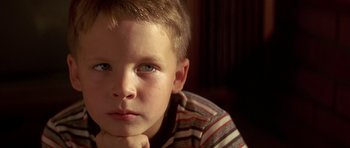 Movie still from “Pulp Fiction” (1994), directed by Quentin Tarantino – A young boy is sitting with his chin resting on his hand; Close Up shot, Low angle