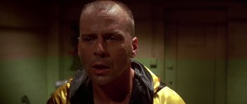 Movie still from “Pulp Fiction” (1994), directed by Quentin Tarantino – A man with a shaved head wearing a yellow and black raincoat; Close Up shot, Low angle
