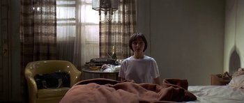 Movie still from “Pulp Fiction” (1994), directed by Quentin Tarantino – A woman sitting on a bed in front of a window; Medium shot, High angle