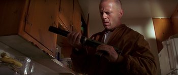 Movie still from “Pulp Fiction” (1994), directed by Quentin Tarantino – A man in a brown jacket is holding a knife; Medium shot, Low angle