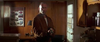 Movie still from “Pulp Fiction” (1994), directed by Quentin Tarantino – A man in a brown jacket holding a camera; Medium shot, Low angle
