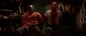 Movie still from “Pulp Fiction” (1994), directed by Quentin Tarantino – Two men sitting in a room covered in fake blood; Medium shot, High angle