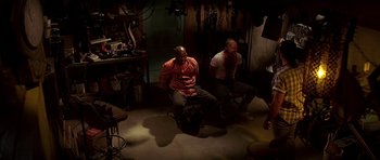 Movie still from “Pulp Fiction” (1994), directed by Quentin Tarantino – Two men sitting in a chair in a dark room; Wide shot, High angle