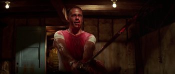 Movie still from “Pulp Fiction” (1994), directed by Quentin Tarantino – A man holding a baseball bat with blood all over his face; Medium shot, Low angle