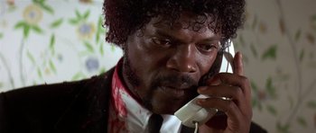 Movie still from “Pulp Fiction” (1994), directed by Quentin Tarantino – A person talking on a cell phone; Close Up shot, Low angle