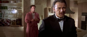 Movie still from “Pulp Fiction” (1994), directed by Quentin Tarantino – A man in a black suit and a man in a red and white checkered shirt; Medium shot, Low angle