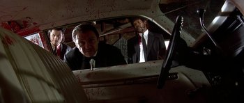 Movie still from “Pulp Fiction” (1994), directed by Quentin Tarantino – Two men in suits and ties looking at each other through a car window; Medium shot, Low angle