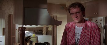Movie still from “Pulp Fiction” (1994), directed by Quentin Tarantino – A young man in a red and white shirt in a kitchen; Close Up shot, Over the shoulder angle